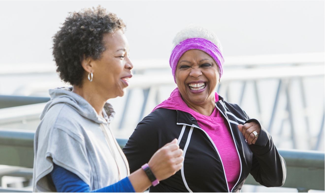 two women power walking near bridge