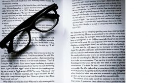 book open to pages with glasses lying across pages