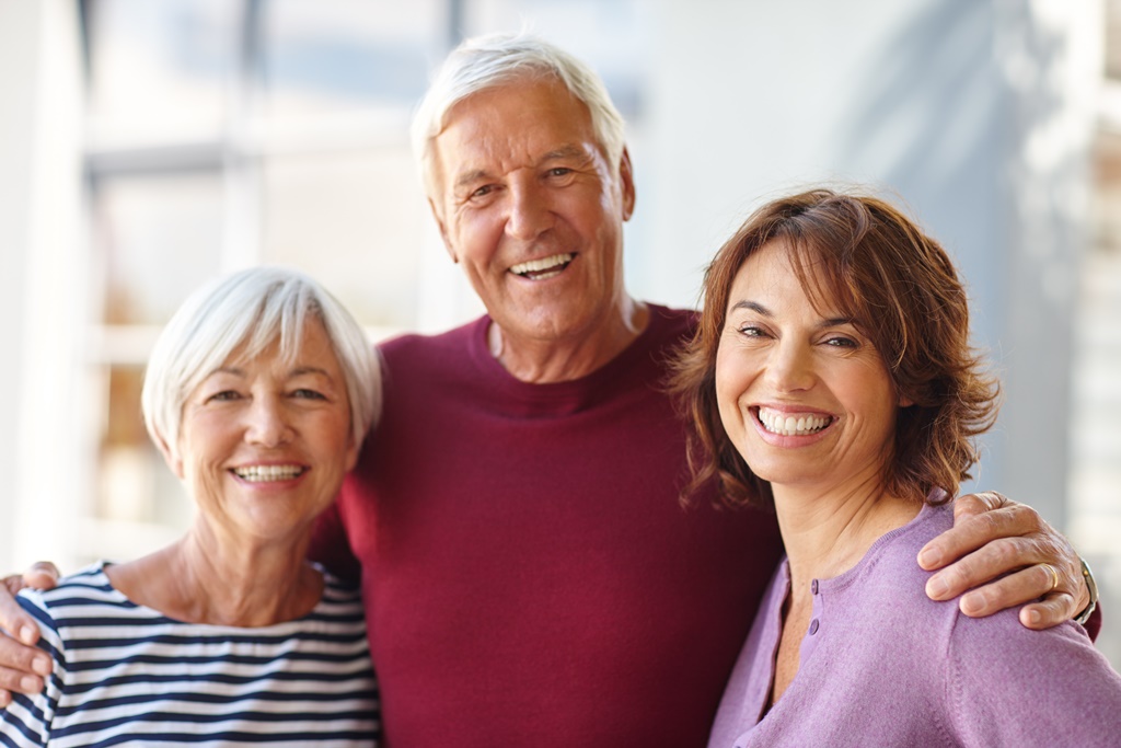 man with arms around wife and daughter