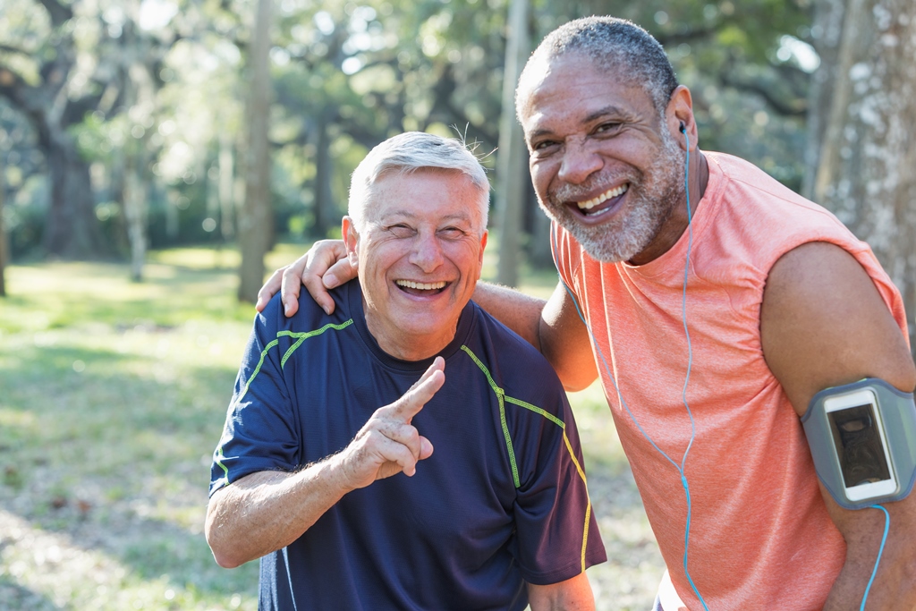 two men smiling and taking a break from their run in the park