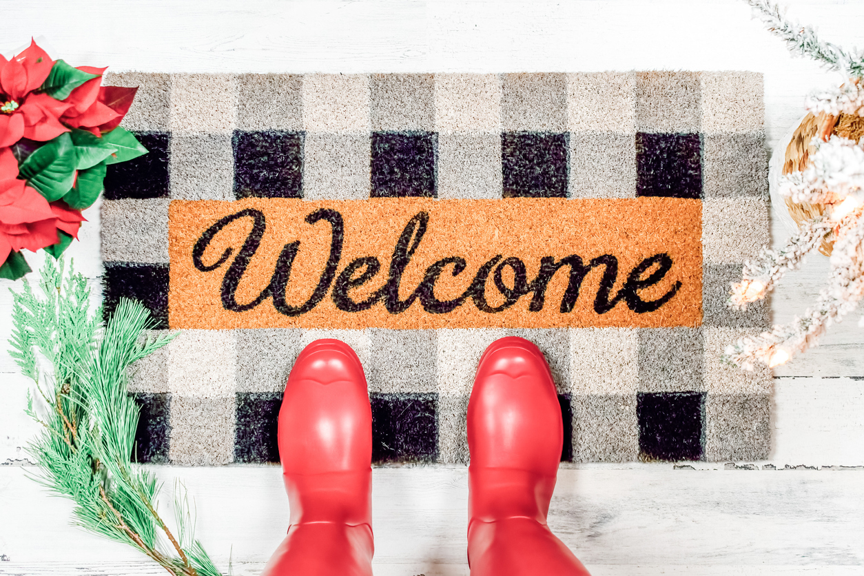 Holiday welcome mat with red boots on it