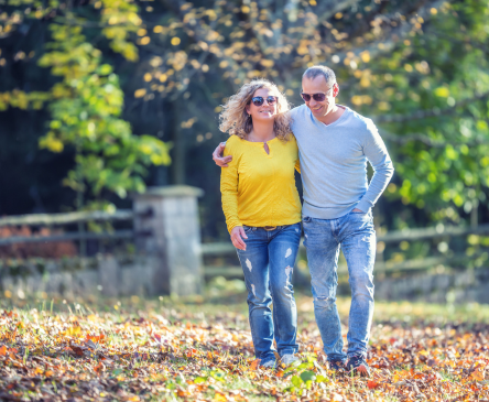 Older adult couple walking in leaves